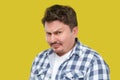 Closeup portrait of serious handsome middle aged business man in casual checkered shirt standing and looking at camera with