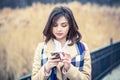 Closeup portrait serious woman talking texting on phone displeased with conversation isolated on light brown park nature Royalty Free Stock Photo