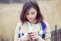 Closeup portrait serious woman talking texting on phone displeased with conversation isolated on light brown park nature Royalty Free Stock Photo