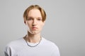 Closeup portrait of serious young man in white t-shirt over gray background Royalty Free Stock Photo