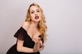 Closeup portrait of sexy blonde girl with sensual lips, passionate young woman with curly hairstyle, beckoning finger Royalty Free Stock Photo