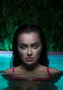 Closeup portrait of brunette woman wearing pink bikini standing in swimming pool Royalty Free Stock Photo