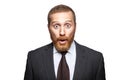 Closeup portrait of shocked handsome businessman with facial beard in black suit standing and looking at camera with big eyes and Royalty Free Stock Photo