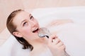 Closeup portrait of singing beautiful blonde young woman relaxing in spa bath with foam having fun happy smiling image Royalty Free Stock Photo