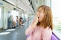 Closeup portrait sleepy, yawn, close eyes young woman in sky train after long hour trip.