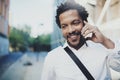 Closeup portrait of smiling American African man using smartphone to call friends at sunny street.Concept of happy young Royalty Free Stock Photo