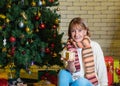 Portrait of smiling beautiful senior Caucasian woman holding Christmas gift with happy face. cheerful woman sits in front of a Royalty Free Stock Photo