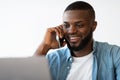 Closeup Portrait Of Smiling Black Man Talking On Cellphone And Using Laptop Royalty Free Stock Photo