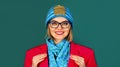 Closeup portrait of smiling fashionable girl in red jacket, knitted hat and blue scarf. Autumn-winter fashion for women Royalty Free Stock Photo
