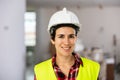 Closeup portrait of smiling female architect in yellow safety vest and helmet at construction site Royalty Free Stock Photo