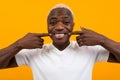 Closeup portrait of a smiling handsome black blond african man with grimace over orange background Royalty Free Stock Photo