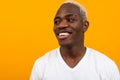 Closeup portrait of a smiling handsome black blond African man on an orange background Royalty Free Stock Photo