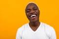 Closeup portrait of a smiling handsome black blond African man on an orange background with copy space Royalty Free Stock Photo