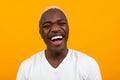 Closeup portrait of a smiling handsome black blond African man on an orange studio background Royalty Free Stock Photo