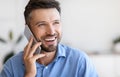 Closeup portrait of smiling handsome young businessman talking on mobile phone indoors Royalty Free Stock Photo