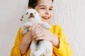 Closeup portrait of a smiling happy child playing at home with a little dog. Pretty little girl cares about the puppy. Adorable Royalty Free Stock Photo