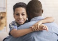 Closeup portrait of smiling little black son hugging father at home Royalty Free Stock Photo