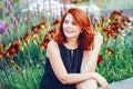 Closeup portrait of smiling middle aged white caucasian woman with waved curly red hair in black dress looking away Royalty Free Stock Photo