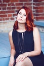 Closeup portrait of smiling middle aged white caucasian woman with waved curly red hair in black dress looking in camera Royalty Free Stock Photo