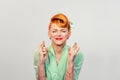 Closeup portrait of a smiling pin up retro vintage hair style woman with fingers crossed Royalty Free Stock Photo