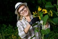 Closeup portrait of smiling woman gardener in gloves with sunflower Royalty Free Stock Photo