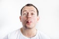 Closeup portrait of smiling 30 years old caucasian white man show his tongue. Guy on white background in white t-shirt. Confident Royalty Free Stock Photo
