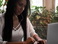 Closeup portrait of smiling young african woman sitting in a cafe with laptop Royalty Free Stock Photo