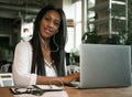 Closeup portrait of smiling young african woman sitting in a cafe with laptop Royalty Free Stock Photo