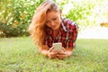 Woman texting by phone and lying on meadow Royalty Free Stock Photo