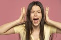 Closeup portrait stressed frustrated woman screaming having temper tantrum isolated on pink background Royalty Free Stock Photo