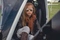 Tween girl in mirrored sunglasses sitting in open helicopter