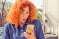 Closeup portrait surprised young woman in hat looking at phone seeing unexpected news or photos with wonder emotion on her face Royalty Free Stock Photo