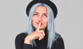 Closeup portrait of teenager female wears black clothes, shows silence sign, looking up, asks to keep information confidential, Royalty Free Stock Photo