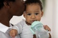 Closeup Portrait Of Thirsty Adorable Black Infant Boy Drinking Water From Bottle Royalty Free Stock Photo