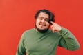 Closeup portrait of a thoughtful fat bearded hispanic guy expressing a thinking gesture by touching his head with his finger Royalty Free Stock Photo