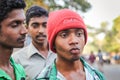 Closeup portrait of three Indian teenagers in formal shirts pose at camera on busy road