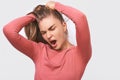 Closeup portrait of tired Caucasian young woman yawning, wearing pink blouse and round transparent eyewear, posing over white Royalty Free Stock Photo