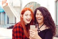 Closeup portrait two surprised girls looking at phone discussing latest gossip news Young shocked funny women friends reading Royalty Free Stock Photo