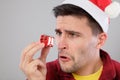 Closeup portrait unhappy, upset man holding small red gift Royalty Free Stock Photo