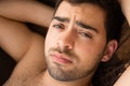 Closeup portrait of unshaven young guy in a hammock, looking at camera