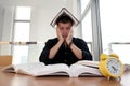 Closeup portrait of white man surrounded by tons of books, alarm clock, stressed from project deadline, study, exams