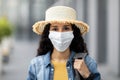 Closeup portrait of woman in face mask and straw hat