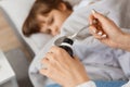 Closeup portrait of woman hand holding spoon with syrup, little unhealthy girl lying on cough, mother taking care of her sick Royalty Free Stock Photo