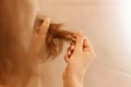 Closeup portrait of woman hands holding dry damaged hair eds, having trichology problem Royalty Free Stock Photo