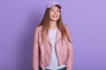 Closeup portrait of woman looking playful at camera, beautiful girl wearing white shirt, pink jacket and cap. Lady standing Royalty Free Stock Photo