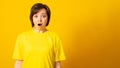 Closeup portrait woman looking surprised in full disbelief wide open mouth isolated yellow background Royalty Free Stock Photo