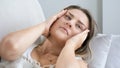 Closeup portrait of woman with migrain touchin her head