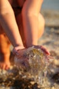Closeup portrait of a woman`s hands holding and saving a jellyfish on the seashore