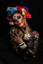 Closeup portrait of woman with a sugar skull makeup dressed with flower crown