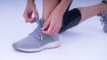 Closeup portrait of a woman tying shoelaces, Beautiful woman tying shoelaces isolated over white background